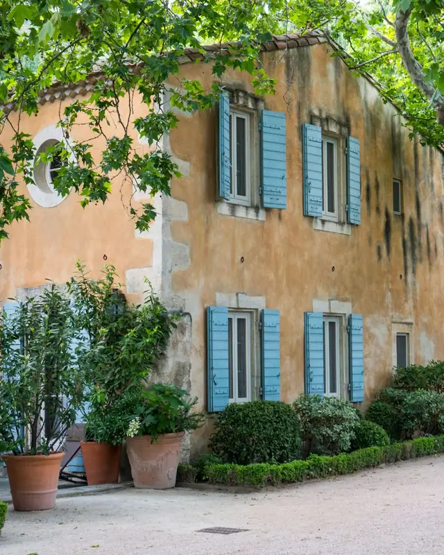 Façade ocre aux volets bleus dans un village du sud de la France